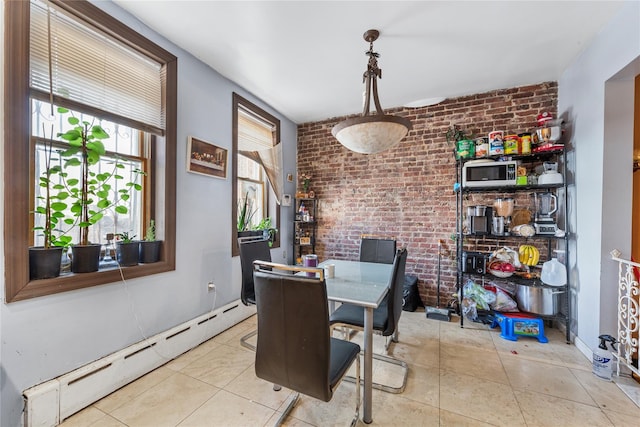 dining room featuring baseboard heating, light tile patterned flooring, and brick wall