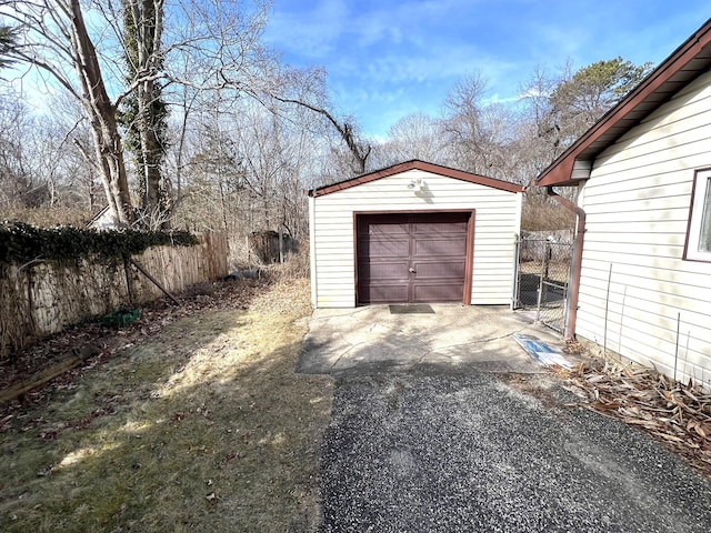 detached garage with driveway and fence