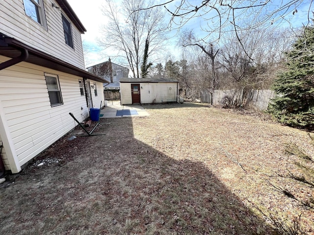 view of yard with a storage shed, a patio, an outdoor structure, and fence