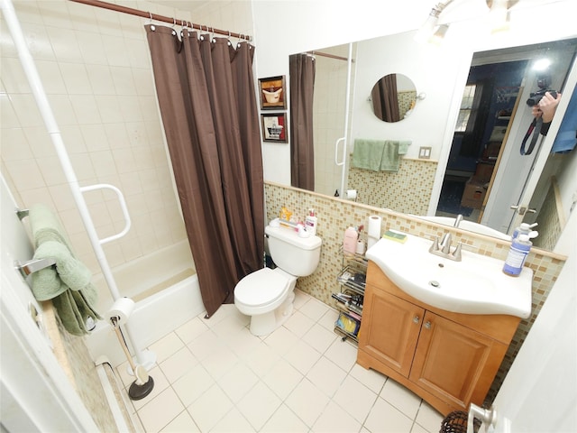 bathroom with tile walls, shower / bathtub combination with curtain, toilet, vanity, and tile patterned flooring