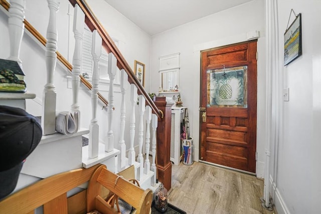 entrance foyer featuring stairway and wood finished floors