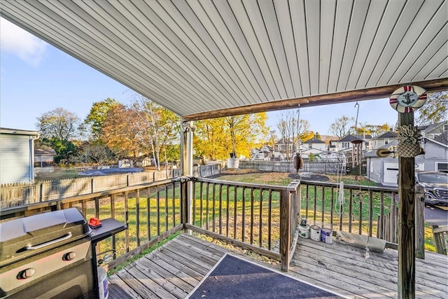 wooden deck featuring a yard, area for grilling, a fenced backyard, and a residential view