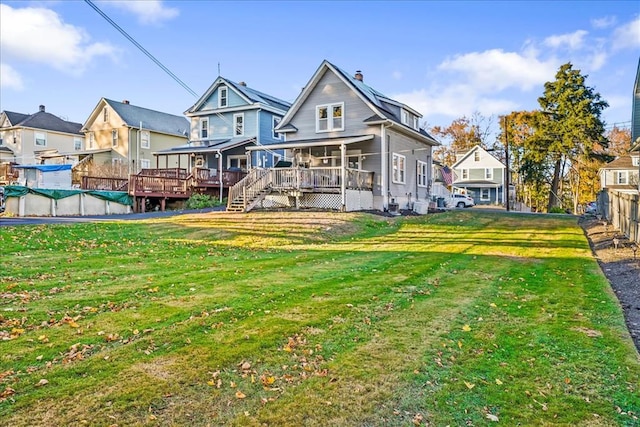 back of property featuring a yard, a chimney, a residential view, and a wooden deck