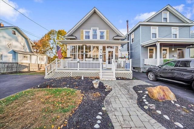 view of front of property with covered porch and fence