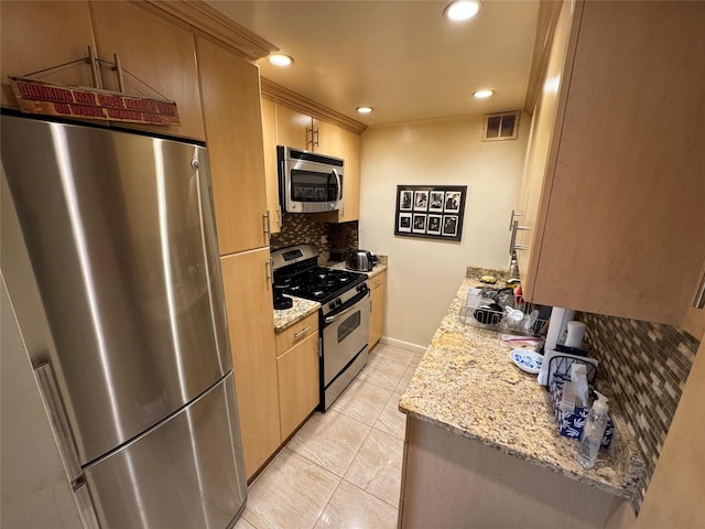 kitchen with appliances with stainless steel finishes, light brown cabinets, decorative backsplash, and light stone counters