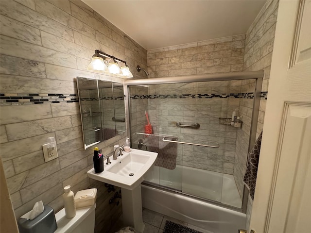 full bathroom featuring combined bath / shower with glass door and a sink