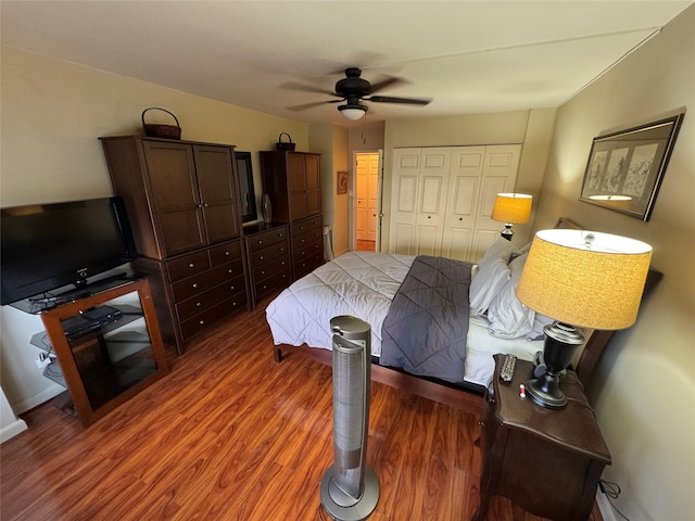 bedroom featuring dark wood-style floors, a ceiling fan, and a closet