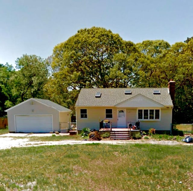 ranch-style house with a garage, a front yard, and an outbuilding