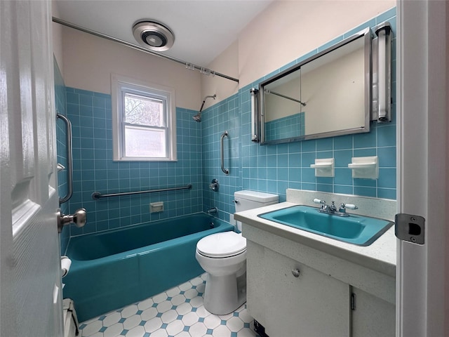 bathroom with shower / bathtub combination, toilet, vanity, tile walls, and tile patterned floors