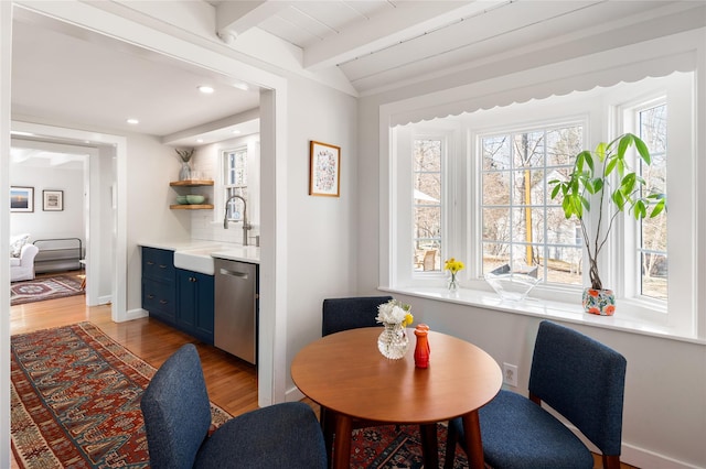 dining area featuring baseboards, vaulted ceiling with beams, light wood-style floors, bar area, and recessed lighting