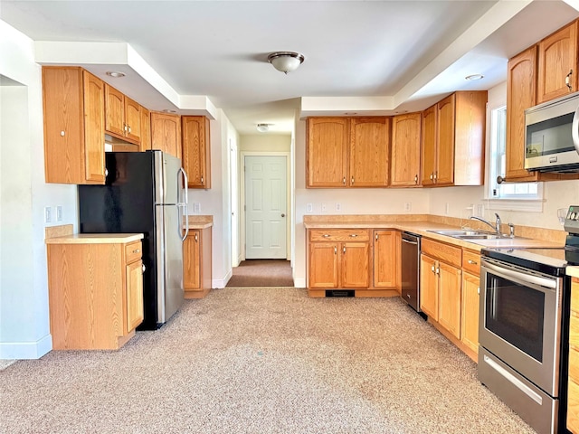 kitchen featuring a sink, stainless steel appliances, light countertops, and baseboards