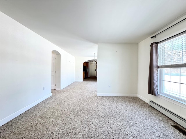 spare room with arched walkways, a baseboard heating unit, carpet floors, and baseboards