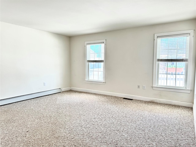 spare room featuring a wealth of natural light, carpet flooring, visible vents, and baseboards