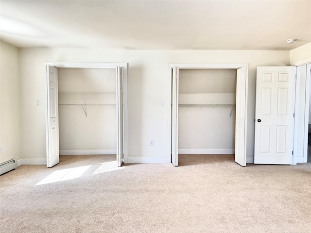 unfurnished bedroom featuring light carpet, baseboards, and multiple closets