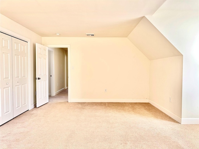 bonus room featuring lofted ceiling, carpet flooring, visible vents, and baseboards