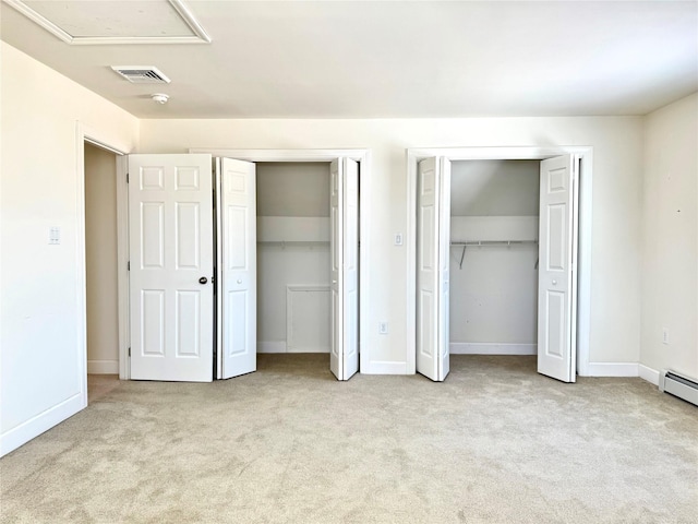 unfurnished bedroom with baseboards, two closets, visible vents, and light colored carpet