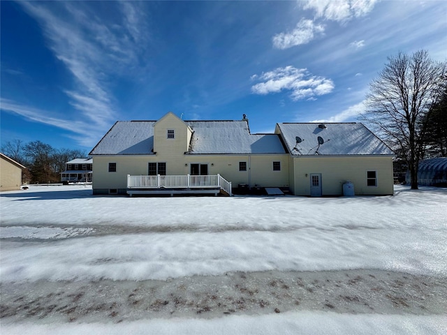 snow covered rear of property featuring a deck