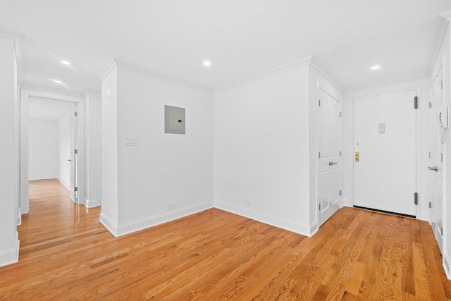 unfurnished room with light wood finished floors, electric panel, baseboards, crown molding, and recessed lighting