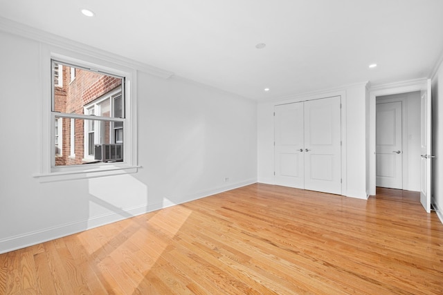 unfurnished bedroom with recessed lighting, baseboards, light wood-style floors, a closet, and crown molding