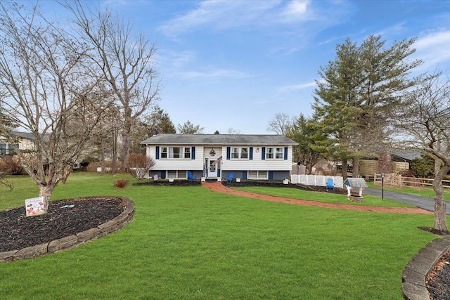 view of front of property with driveway, fence, and a front lawn