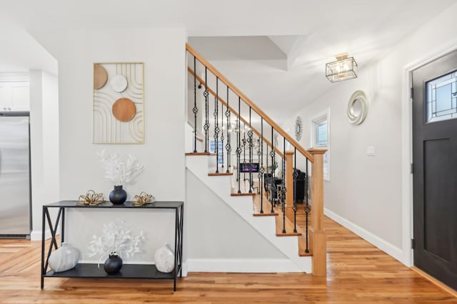 foyer featuring stairway, baseboards, a wealth of natural light, and wood finished floors