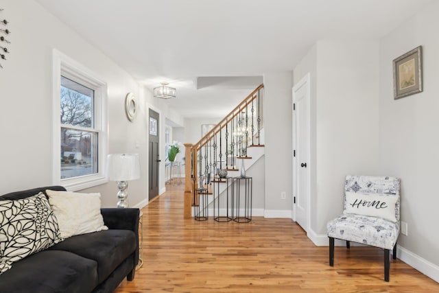 interior space with light wood-style floors, baseboards, and stairway