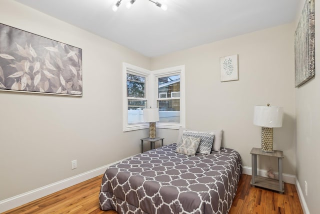 bedroom featuring wood finished floors and baseboards