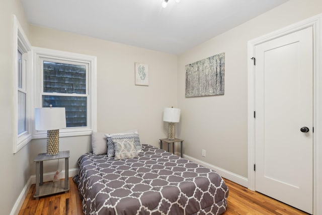 bedroom with baseboards and wood finished floors