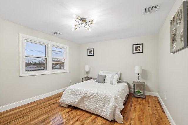 bedroom featuring visible vents, baseboards, and wood finished floors