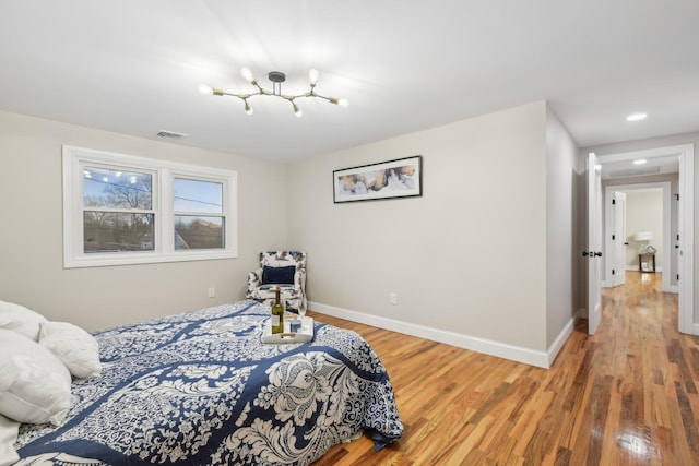 bedroom with visible vents, baseboards, and wood finished floors