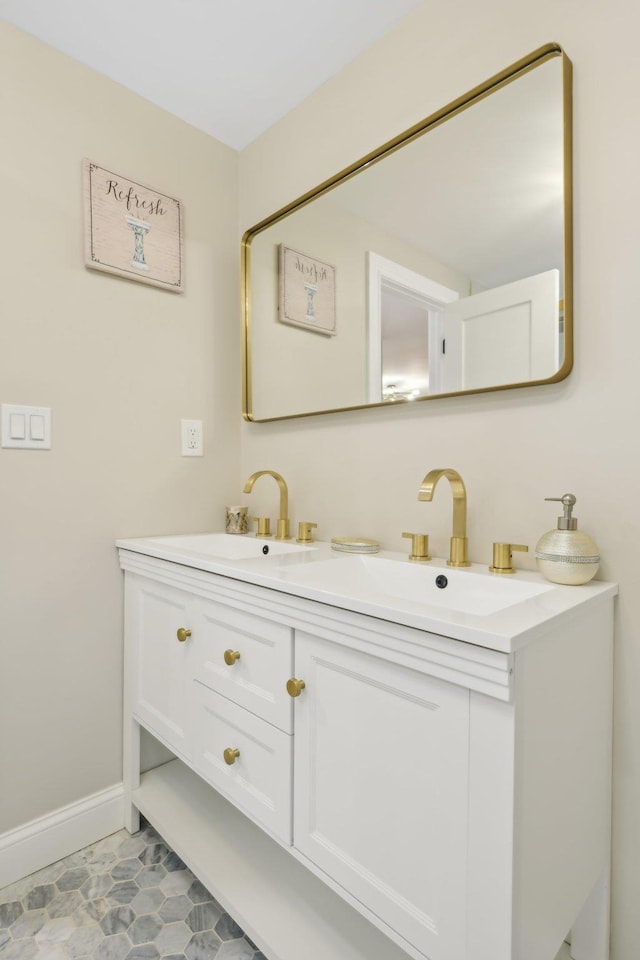 bathroom featuring double vanity, a sink, and baseboards