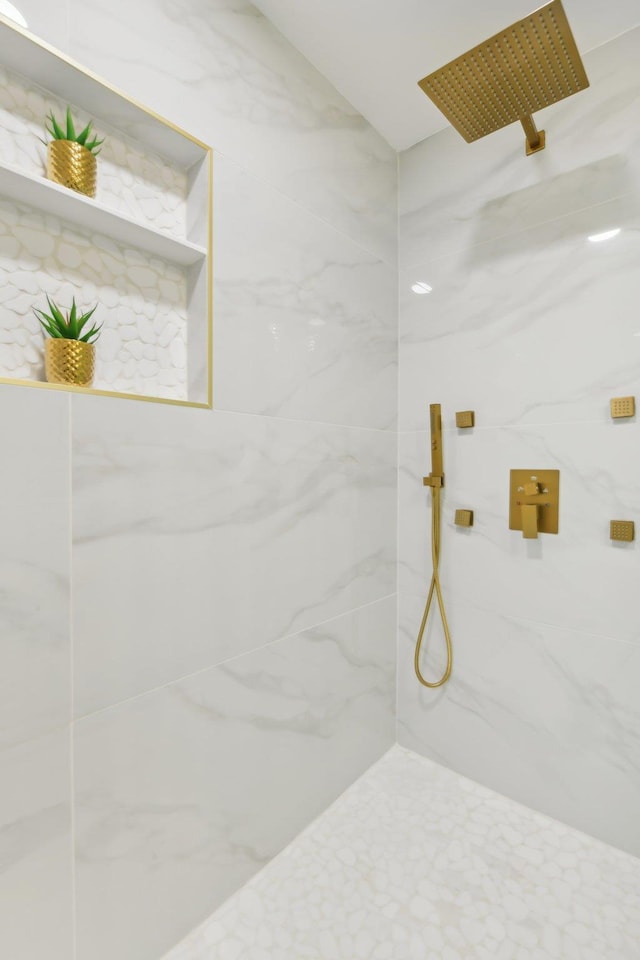 bathroom featuring a marble finish shower