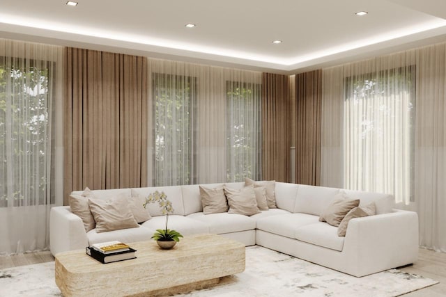 living room featuring recessed lighting, a raised ceiling, and wood finished floors