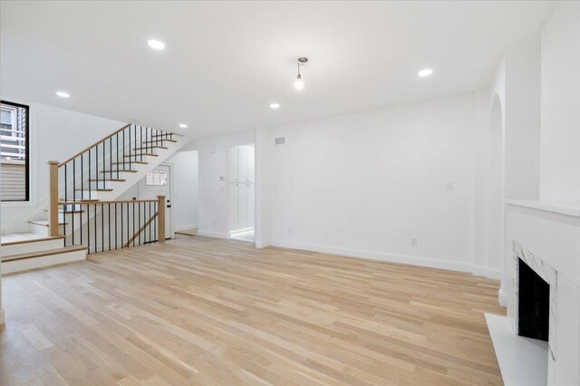 670 Emerson St, Woodmere, NY 11598 - unfurnished living room featuring light wood finished floors, recessed lighting, stairway, and a fireplace