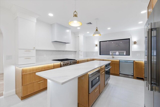 670 Emerson St, Woodmere, NY 11598 - kitchen with high end appliances, modern cabinets, hanging light fixtures, light stone counters, and a center island