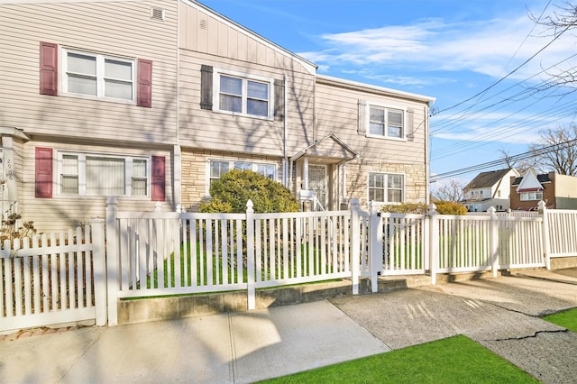 view of front facade featuring a fenced front yard and stone siding