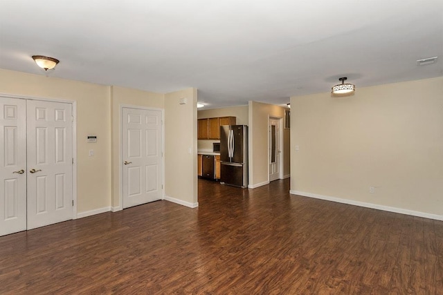 unfurnished living room with visible vents, baseboards, and dark wood finished floors