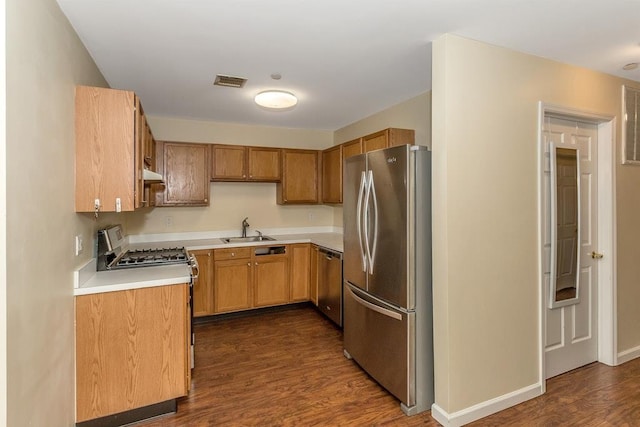 kitchen with a sink, visible vents, light countertops, appliances with stainless steel finishes, and dark wood-style floors