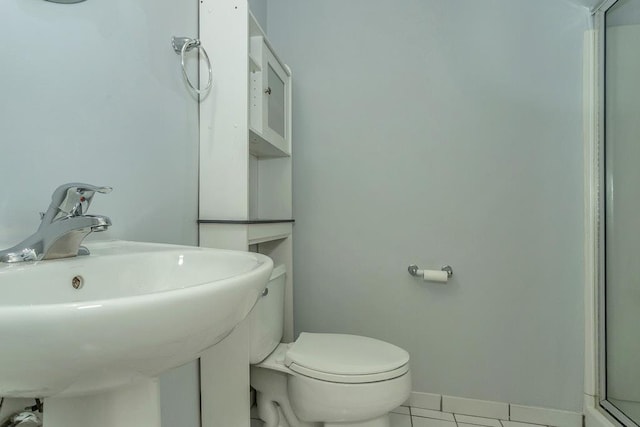 bathroom with baseboards, a sink, toilet, and tile patterned floors