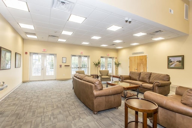 living room featuring a paneled ceiling, visible vents, light colored carpet, and french doors