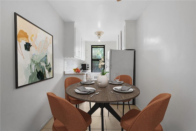 dining room featuring baseboards and light tile patterned floors