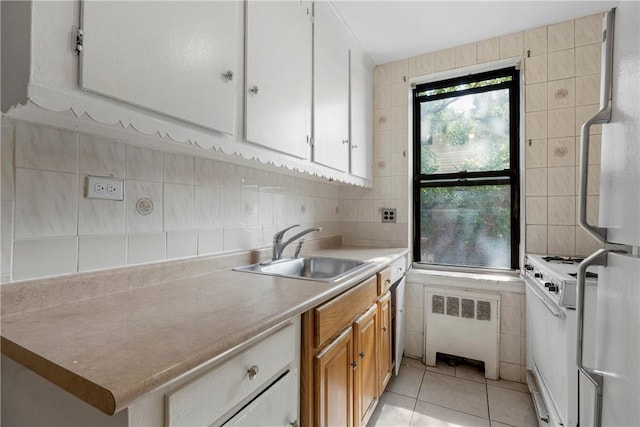 kitchen with a sink, tile walls, light countertops, decorative backsplash, and radiator heating unit