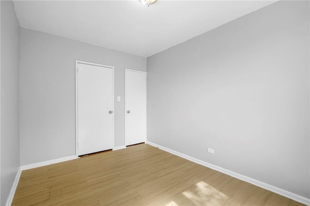 unfurnished bedroom featuring light wood-style flooring and baseboards