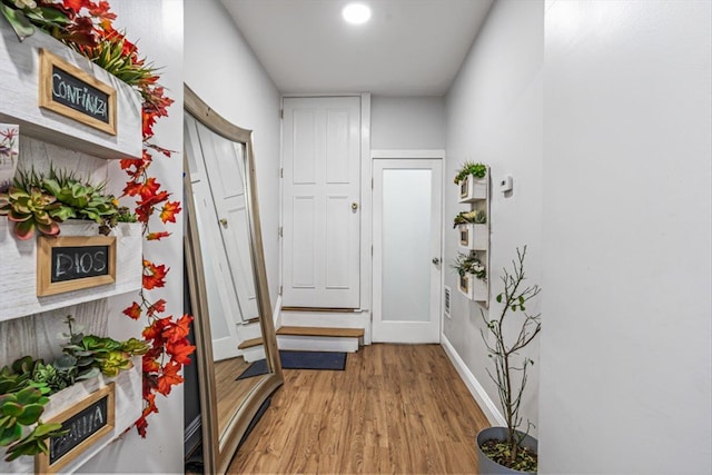 hallway with baseboards and light wood-style floors