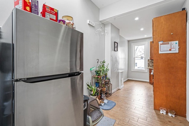 interior space with recessed lighting, light wood-type flooring, freestanding refrigerator, and baseboards