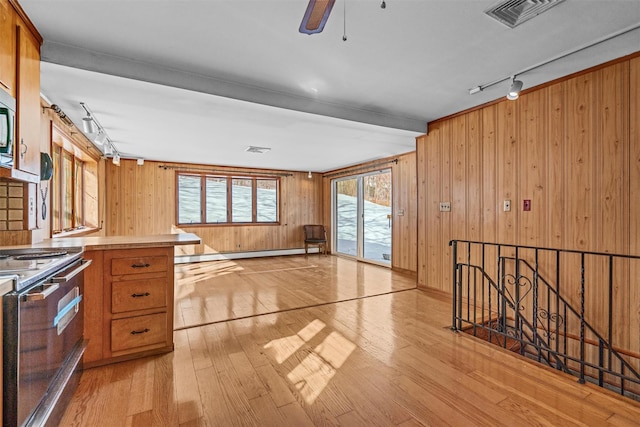 kitchen with light wood-style flooring, light countertops, visible vents, and electric range oven