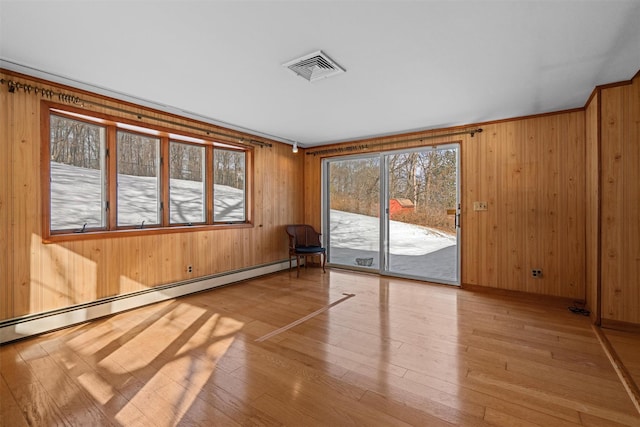 unfurnished sunroom featuring visible vents and a baseboard heating unit