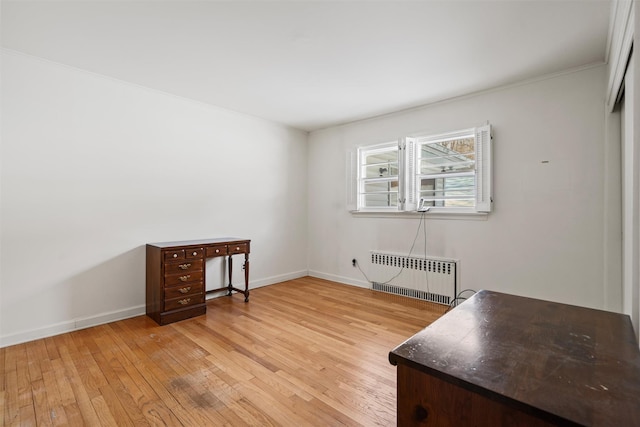 interior space with light wood-style floors, radiator heating unit, and baseboards