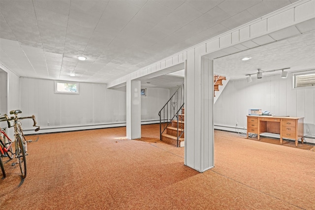 below grade area featuring a baseboard heating unit, carpet, stairway, and baseboard heating