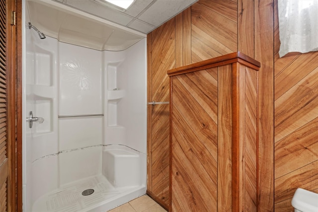 full bath with a stall shower, a paneled ceiling, and tile patterned floors